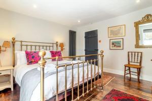 - une chambre avec un lit et une chaise dans l'établissement Curlew Cottage Woodbridge Suffolk Cosy Victorian cottage for couple and dog, à Woodbridge