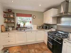 a kitchen with white cabinets and a stove top oven at Sawdon Heights in Sawdon