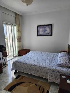 1 dormitorio con 1 cama con edredón azul en CasaSlim Hammamet, en Hammamet