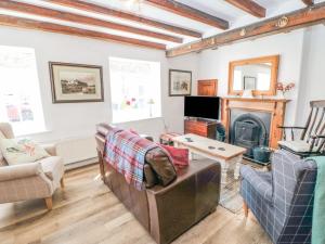 a living room with a couch and a fireplace at Chapel Cottage in Ebberston