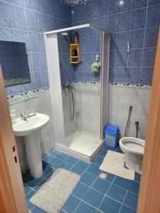baño de azulejos azules con ducha y aseo en CasaSlim Hammamet, en Hammamet