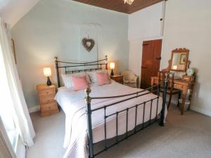 a bedroom with a bed with pink pillows on it at Chapel Cottage in Ebberston