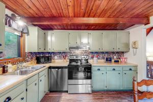 a kitchen with white cabinets and a stove top oven at Adventure Awaits in Rogers +14 photos