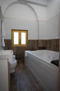 ein Badezimmer mit einer Badewanne, einem WC und einem Waschbecken in der Unterkunft Cala Baby Accommodation in Gravina in Puglia