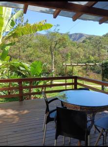 a patio with a table and chairs on a deck at Pousada Verde Folhas in Casa Branca