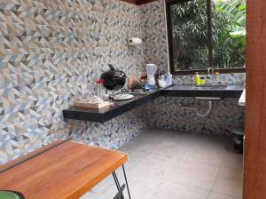 baño con pared de piedra con fregadero y mesa en Pousada Verde Folhas, en Casa Branca