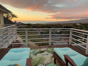 a deck with a white fence and chairs on a balcony at Coastal Waikoloa Cottage Sleeps 10 in Waikoloa Village