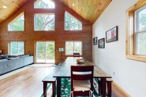 a large living room with a wooden ceiling with windows at Shallow Brook in Jay