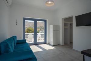a living room with a blue couch and a television at Traditional White House 2 in Prodromos Paros