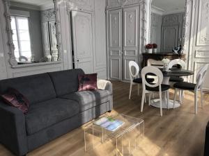 salon z kanapą i stołem w obiekcie Maison Gabriel Appartement PLUME w mieście Abbeville