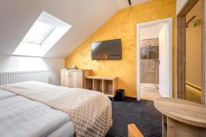 - une chambre avec un lit et une télévision murale dans l'établissement Penzion Golden Crown, à Český Krumlov