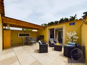 een patio met banken en een tafel en stoelen bij Le bastidon de Stéphanie Saint Rémy de Provence in Saint-Rémy-de-Provence