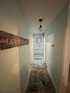 a hallway with a god blessing sign on the wall at The Cocoa Cottage in Cocoa