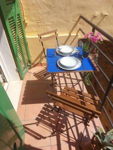 a blue table and chairs on a balcony with plates at Il 55 dei Bastioni in Bordighera