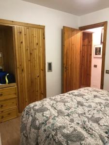 a bedroom with a bed and a wooden closet at appartamento incantevole con camino in Rocca di Mezzo