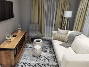 a living room with a white couch and a table at Kings view exclusive villas (KVEV) in Pretoria-Noord