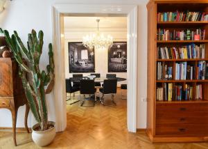 un comedor con una mesa y una estantería con libros en Neoclassical Luxury Apartment Ljubljana, en Liubliana