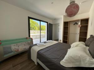 a bedroom with a bed and a large window at Les Jardins des Brandes in La Rochelle