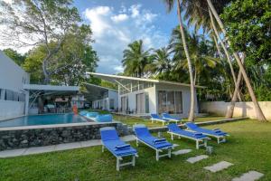 dom z basenem i niebieskimi krzesłami w obiekcie Mawella Beach Resort w Tangalli