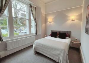 a bedroom with a bed and a large window at 3 Sheets To The Wind, Boutique Holiday Apartment in Torquay in Torquay