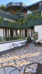a hotel with a patio with a table and benches at Kai Hotel in Tbilisi City