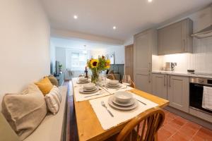 a kitchen with a dining room table with plates and flowers on it at Stylish, comfortable, convenient! in Bala