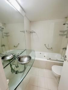 a bathroom with a glass sink and a tub at Park Soho Recoleta in Buenos Aires