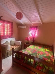 1 dormitorio con cama, sofá y ventanas en Cocon Tropical en Vieux-Habitants