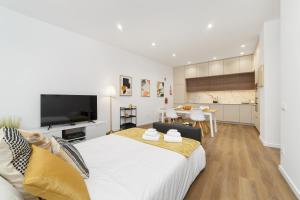 a bedroom with a large bed and a kitchen at LUMO Flat Fátima in Fátima