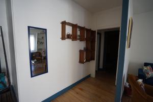 a hallway with a mirror on a white wall at La maison du Thoré in Saint-Amans-Valtoret