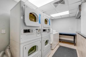 a laundry room with three washer and dryers at Ocean Park Resort - Oceana Resorts Vacation Rentals in Myrtle Beach