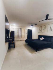Schlafzimmer mit einem schwarzen Bett und einem Schreibtisch in der Unterkunft Opulence Beach Resort Awas, Alibaug in Alibag