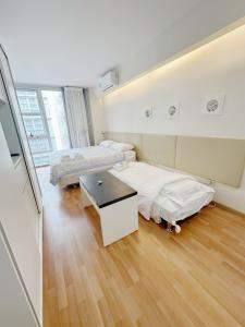 a room with two beds and a table in it at Park Soho Recoleta in Buenos Aires