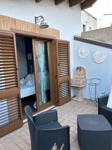 eine Terrasse mit Holztüren und -stühlen sowie einem Bett in der Unterkunft B&B Savoia San Salvo in San Salvo