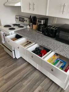 a kitchen with a counter with white drawers at Exquisite 2 Bedroom Apartment in Camrose +21 photos