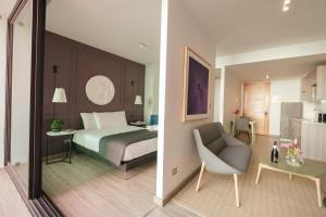 ein Schlafzimmer mit einem Bett und einem Stuhl sowie eine Küche in der Unterkunft Studio 56 by Terrado in Antofagasta