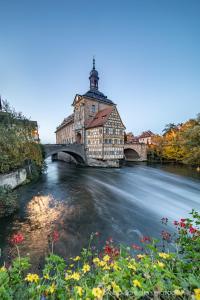 a building next to a river with a bridge at Adam&Eva in Bamberg