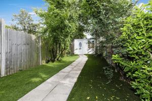 een loopbrug in een tuin met een hek bij Your Chic 3BR Home Comfort and Style in London in Londen