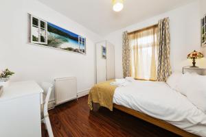 Habitación pequeña con cama y ventana en Your Chic 3BR Home Comfort and Style in London, en Londres