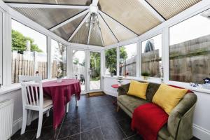 a conservatory with a couch and a table at Your Chic 3BR Home Comfort and Style in London in London