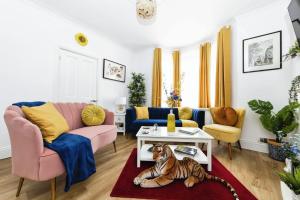 een woonkamer met een roze bank en een tijger op een tapijt bij Your Chic 3BR Home Comfort and Style in London in Londen