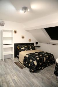 a bedroom with a large bed with black and white sheets at Jupiter in Saint-Quentin