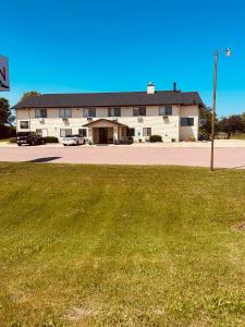 a building with a grass field in front of it at Arlington Inn in Arlington