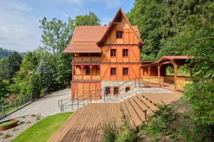 ein großes Holzhaus mit einer Holzterrasse in der Unterkunft Villa Winkler in Międzygórze