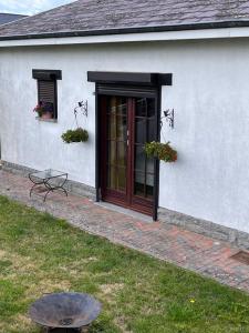 a white house with a brown door and a table at Chez Tantine Nadine in Couvin