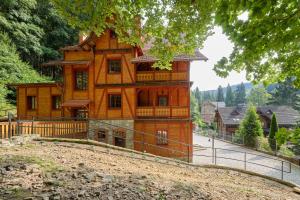 een groot houten huis met een hek eromheen bij Villa Winkler in Miedzygorze