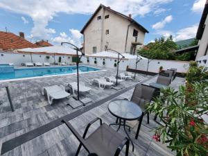 un patio con mesa, sillas y piscina en Fenix Apartments en Soko Banja