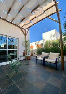 un patio avec deux bancs et une pergola dans l'établissement Aldeia de Portimão, à Portimão