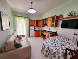 a living room with a couch and a kitchen at Casa Simonetta Il Glicine in Ponza