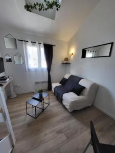 a living room with a couch and a bed at REGLISSE-12 min des parcs Walt Disney-Arrivée Autonome - Parking & wifi Gratuit in Bussy-Saint-Georges